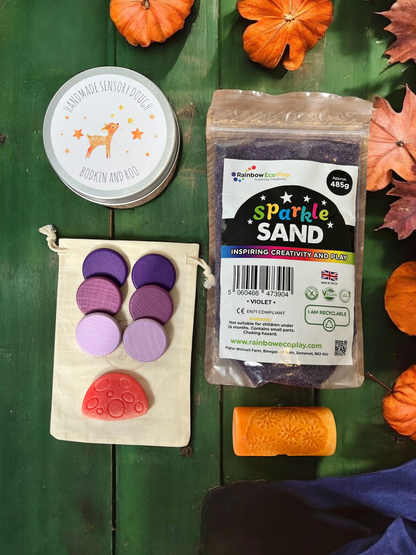 Cub & Bear Ltd sensory play kit featuring violet sparkle sand, handmade dough, wooden discs, and an orange roller.